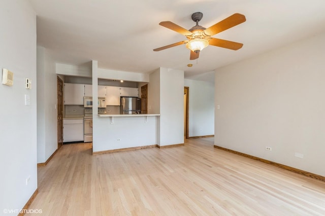 4301 W Shamrock Ln Unit 1C, Mchenry, IL 60050 - unfurnished living room with light wood-style floors and ceiling fan