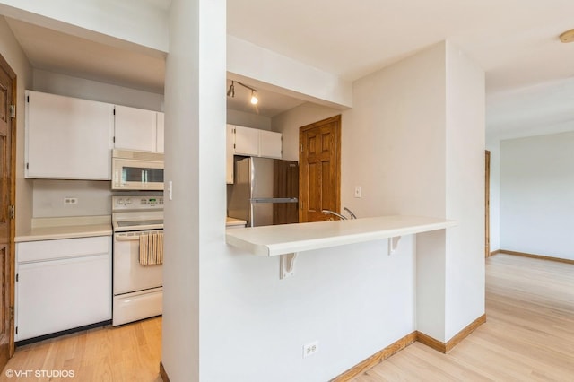 4301 W Shamrock Ln Unit 1C, Mchenry, IL 60050 - kitchen featuring white appliances, light wood finished floors, light countertops, and a kitchen bar