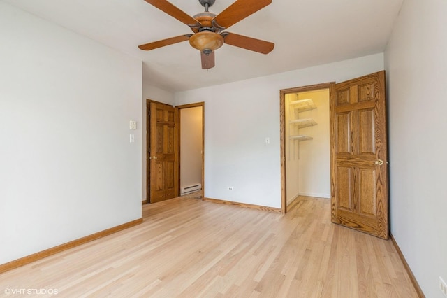 4301 W Shamrock Ln Unit 1C, Mchenry, IL 60050 - unfurnished bedroom featuring a walk in closet, light wood-style flooring, a closet, baseboard heating, and a ceiling fan