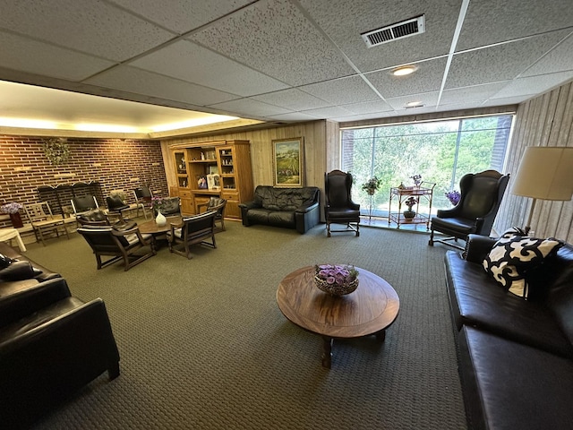 200 Deborah Ln Unit 13C, Wheeling, IL 60090 - living room featuring a drop ceiling, carpet flooring, wooden walls, and brick wall