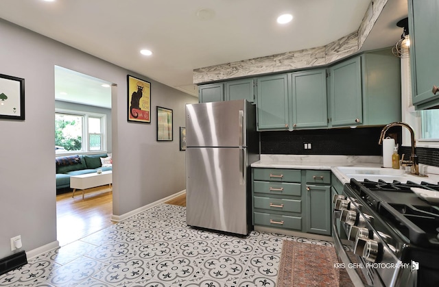1601 Bolling Ave, Johnsburg, IL 60051 - kitchen featuring freestanding refrigerator, range with gas cooktop, recessed lighting, green cabinets, and tasteful backsplash