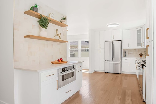 716 Somerset Ln, Darien, IL 60561 - kitchen featuring stainless steel appliances, open shelves, decorative backsplash, light wood finished floors, and light countertops