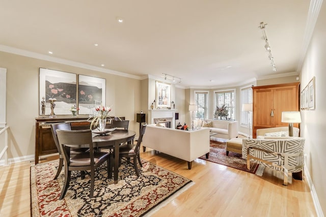 917 W Gunnison St Unit 1W, Chicago, IL 60640 - dining room featuring track lighting, crown molding, a fireplace, light wood-style flooring, and recessed lighting