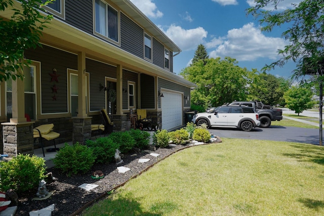 281 Fox Chase Dr N, Oswego, IL 60543 - view of grassy yard featuring covered porch, asphalt driveway, and a garage