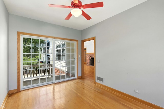 4829 Linscott Ave, Downers Grove, IL 60515 - empty room featuring wood finished floors, a ceiling fan, and a fireplace