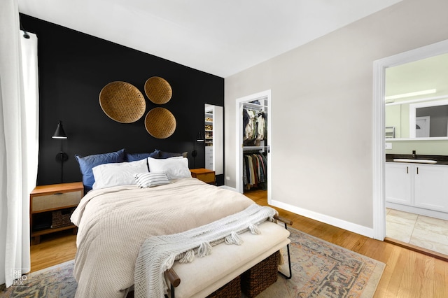 2636 N Fairfield Ave Unit 2N, Chicago, IL 60647 - bedroom with a spacious closet, light wood-style flooring, connected bathroom, and a closet