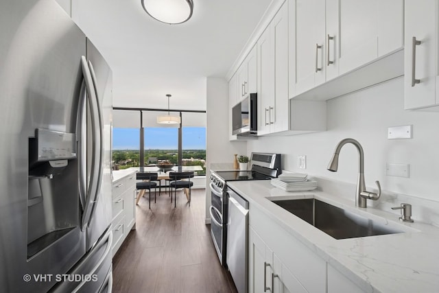 5445 N Sheridan Rd Unit 1515, Chicago, IL 60640 - kitchen with stainless steel appliances, white cabinets, light stone counters, decorative light fixtures, and floor to ceiling windows