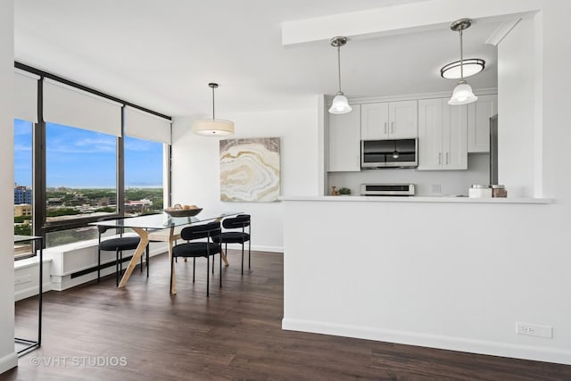 5445 N Sheridan Rd Unit 1515, Chicago, IL 60640 - kitchen with stainless steel microwave, range, decorative light fixtures, dark wood-style flooring, and floor to ceiling windows