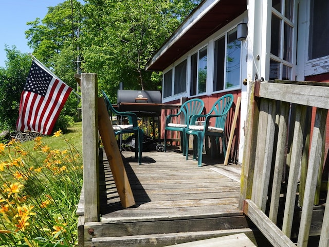 7084 N River Rd, Byron, IL 61010 - wooden deck with a sunroom and a grill