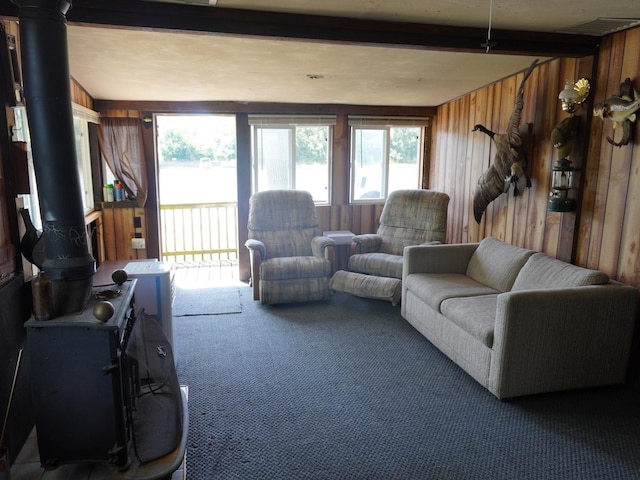 7084 N River Rd, Byron, IL 61010 - carpeted living area featuring beam ceiling, wood walls, and a wood stove