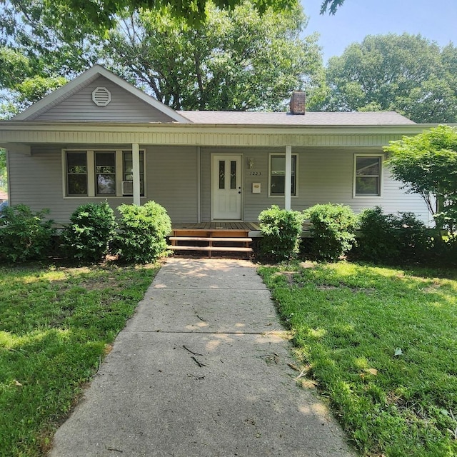1223 Putnam St, Peru, IL 61354 - view of front of house featuring a chimney, a porch, and a front lawn