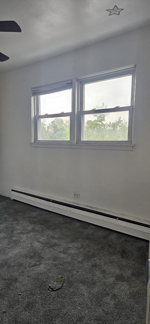 1541 Harlem Ave Unit 2S, Forest Park, IL 60130 - carpeted empty room featuring a baseboard radiator and ceiling fan