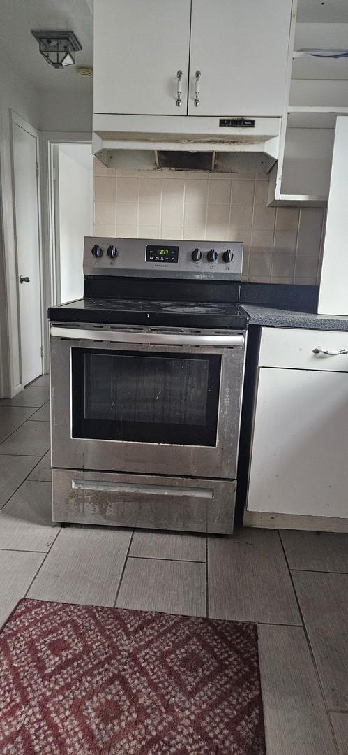 1541 Harlem Ave Unit 2S, Forest Park, IL 60130 - kitchen featuring stainless steel electric range, ventilation hood, decorative backsplash, light tile patterned flooring, and dark countertops