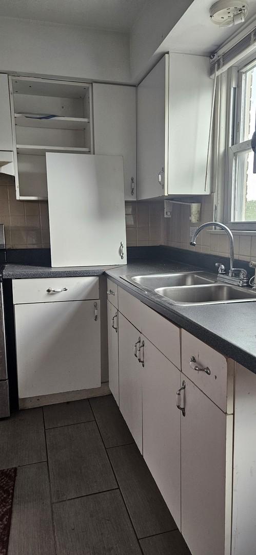 1541 Harlem Ave Unit 2S, Forest Park, IL 60130 - kitchen featuring white cabinets, backsplash, and dark countertops