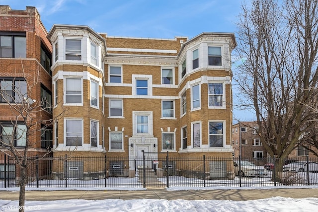 745 S Independence Blvd Unit 3N, Chicago, IL 60624 - snow covered building featuring a fenced front yard and a view of apartment building / complex