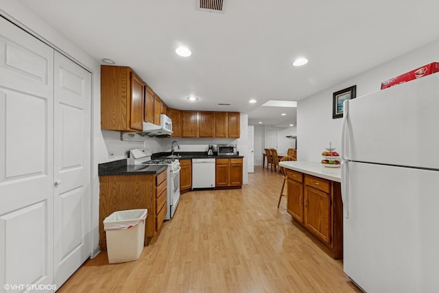 2397 Pebble Beach Ln, Riverwoods, IL 60015 - kitchen with white appliances, light wood-style floors, recessed lighting, brown cabinets, and dark countertops