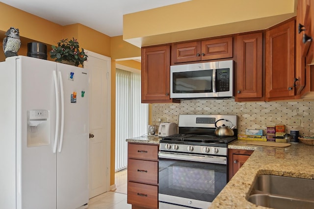17W455 Concord Pl, Darien, IL 60561 - kitchen with appliances with stainless steel finishes, brown cabinets, decorative backsplash, and light stone counters