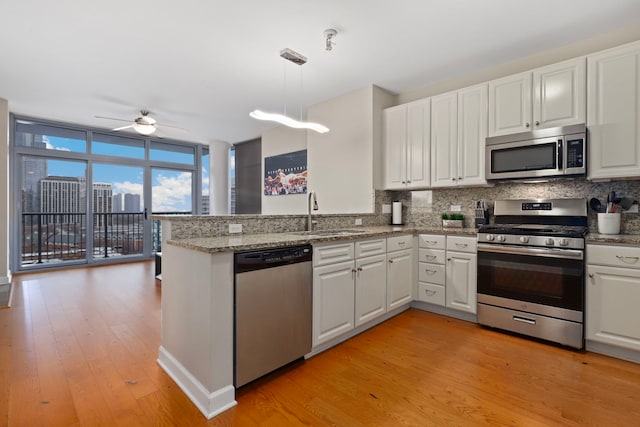 1600 S Prairie Ave Unit 1204, Chicago, IL 60616 - kitchen with appliances with stainless steel finishes, tasteful backsplash, white cabinetry, ceiling fan, and a peninsula