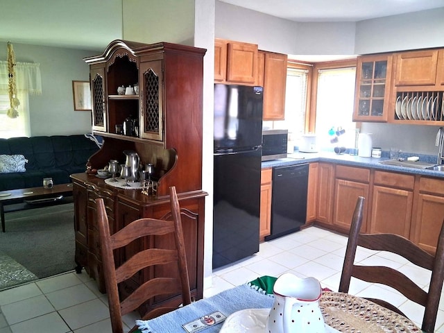 kitchen featuring black appliances, light tile patterned flooring, open shelves, glass insert cabinets, and brown cabinetry