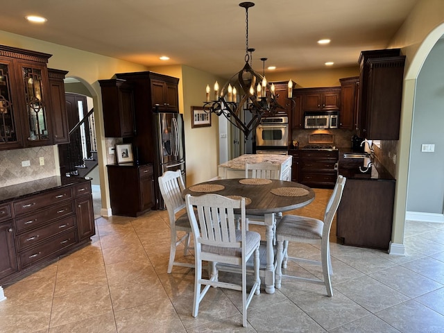 4213 Steam Mill Ct, Oswego, IL 60543 - dining space with arched walkways, a chandelier, recessed lighting, and light tile patterned floors