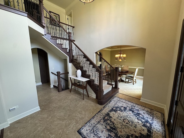 4213 Steam Mill Ct, Oswego, IL 60543 - entrance foyer featuring arched walkways, a chandelier, crown molding, a high ceiling, and stairs