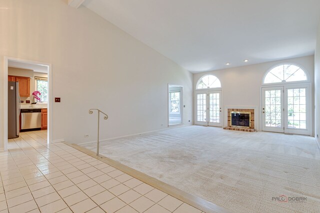 122 Kilchurn Ln, Inverness, IL 60067 - unfurnished living room with high vaulted ceiling, light carpet, plenty of natural light, light tile patterned flooring, and a fireplace
