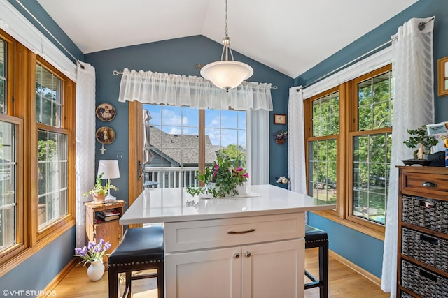 11910 Somerset Rd, Orland Park, IL 60467 - kitchen featuring light wood finished floors, lofted ceiling, a breakfast bar area, healthy amount of natural light, and white cabinetry