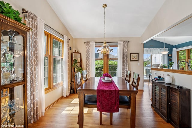 11910 Somerset Rd, Orland Park, IL 60467 - dining area with vaulted ceiling, a chandelier, and wood finished floors