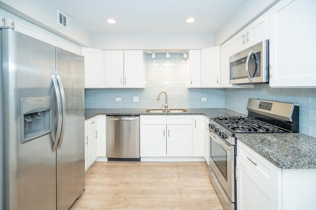 4833 W 109th St Unit 103, Oak Lawn, IL 60453 - kitchen featuring appliances with stainless steel finishes, light wood-style floors, dark stone counters, white cabinetry, and recessed lighting