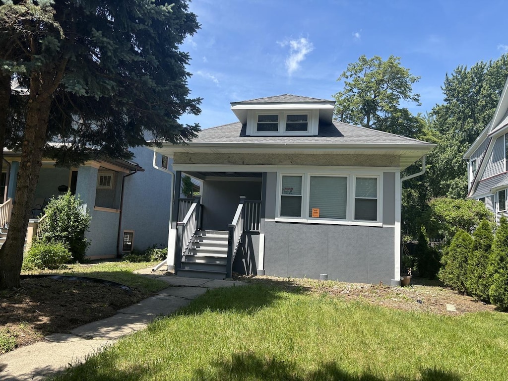 139 N Humphrey Ave, Oak Park, IL 60302 - bungalow-style home with covered porch, a front yard, and stucco siding