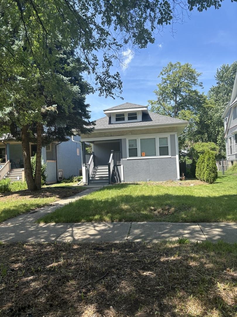 139 N Humphrey Ave, Oak Park, IL 60302 - bungalow with a front lawn, covered porch, a shingled roof, and stucco siding
