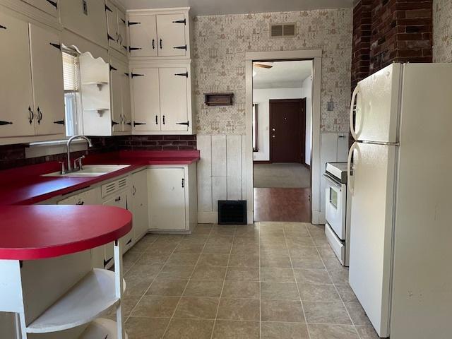 1322 N Prairie Ave, Joliet, IL 60435 - kitchen featuring white appliances, white cabinetry, light tile patterned flooring, and dark countertops