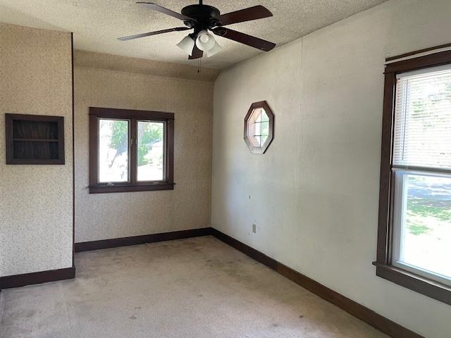 1322 N Prairie Ave, Joliet, IL 60435 - empty room with light carpet, a ceiling fan, healthy amount of natural light, and a textured ceiling