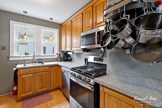 409 E Main St, Peotone, IL 60468 - kitchen with appliances with stainless steel finishes, light wood-style floors, pendant lighting, and light countertops