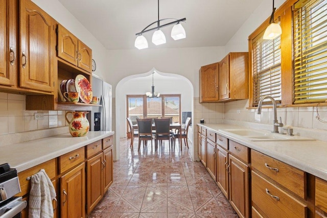 1619 S 61st Ave, Cicero, IL 60804 - kitchen with a chandelier, arched walkways, light countertops, and brown cabinets