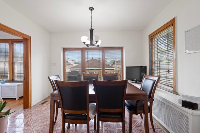 1619 S 61st Ave, Cicero, IL 60804 - dining room featuring a chandelier, radiator heating unit, and light tile patterned flooring