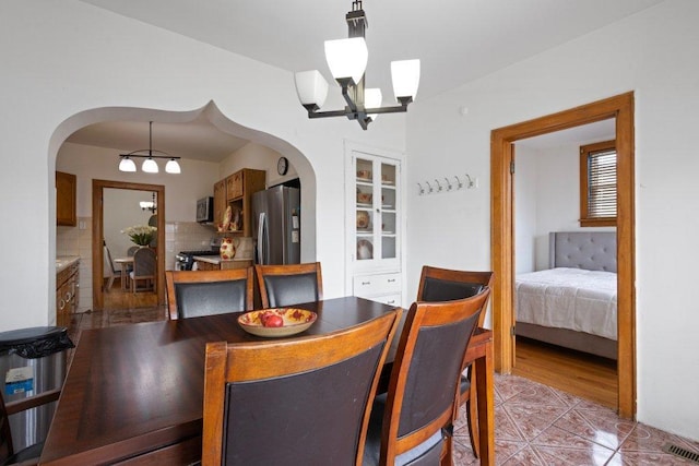 1619 S 61st Ave, Cicero, IL 60804 - dining room with arched walkways, a chandelier, and light tile patterned floors
