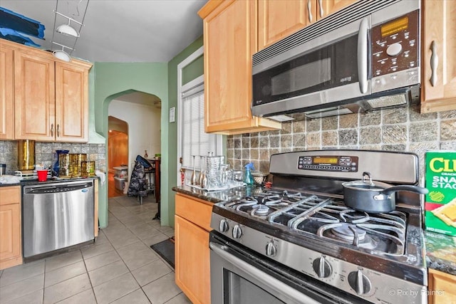 6121 N Hoyne Ave Unit 1S, Chicago, IL 60659 - kitchen with stainless steel appliances, light brown cabinets, arched walkways, and tasteful backsplash