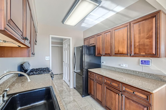 20 N Tower Rd Unit 12M, Oak Brook, IL 60523 - kitchen with freestanding refrigerator, range with gas cooktop, brown cabinets, and light stone counters