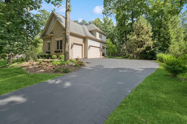 5803 Tomlinson Dr, Mchenry, IL 60050 - view of side of property with asphalt driveway, brick siding, a lawn, a garage, and a shingled roof