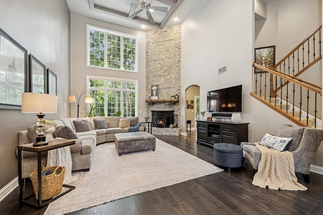 5803 Tomlinson Dr, Mchenry, IL 60050 - living room with a towering ceiling, ceiling fan, dark wood-style flooring, a brick fireplace, and stairs