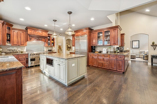 5803 Tomlinson Dr, Mchenry, IL 60050 - kitchen with built in appliances, arched walkways, glass insert cabinets, light stone counters, and brown cabinetry
