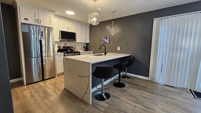 16 Forest Ln, Cary, IL 60013 - kitchen featuring appliances with stainless steel finishes, a kitchen breakfast bar, white cabinetry, light wood-style flooring, and recessed lighting