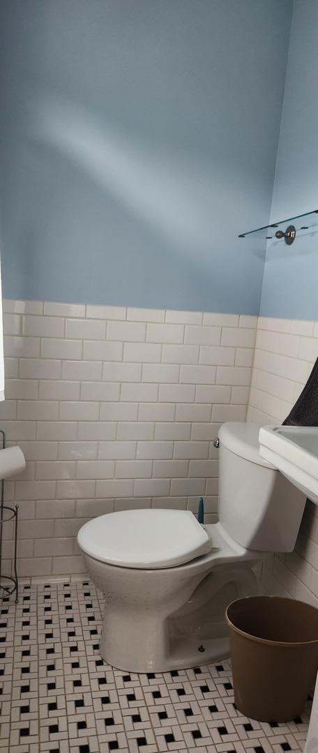 927 Clark St, Marseilles, IL 61341 - bathroom with tile walls, a wainscoted wall, and tile patterned flooring