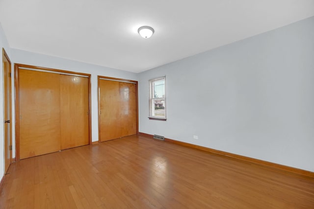 2621 Ridge Rd, Lansing, IL 60438 - unfurnished bedroom featuring multiple closets and wood finished floors