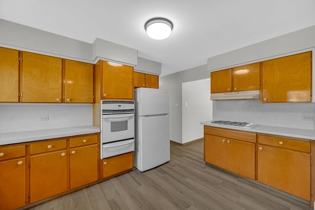 2621 Ridge Rd, Lansing, IL 60438 - kitchen with white appliances, a warming drawer, under cabinet range hood, light wood-type flooring, and light countertops