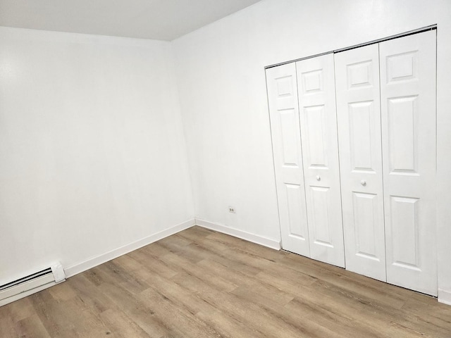 543 E 60th St Unit 1, Chicago, IL 60637 - unfurnished bedroom with a baseboard heating unit, light wood-style flooring, and a closet
