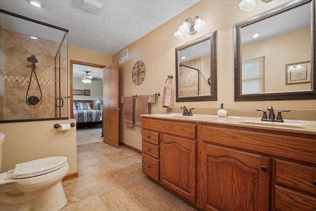 2210 Hedgewood Dr, Bloomington, IL 61704 - ensuite bathroom featuring tiled shower, double vanity, ceiling fan, and a textured ceiling
