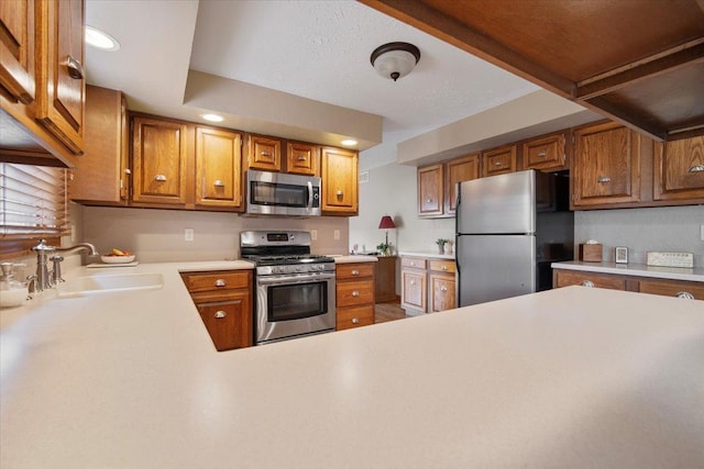 2210 Hedgewood Dr, Bloomington, IL 61704 - kitchen featuring stainless steel appliances, light countertops, brown cabinets, and recessed lighting