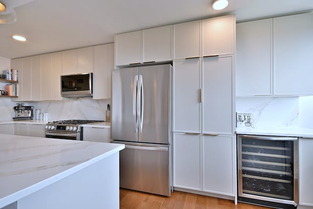 3950 N Lake Shore Dr Unit 810B, Chicago, IL 60613 - kitchen featuring stainless steel appliances, wine cooler, open shelves, light stone countertops, and backsplash